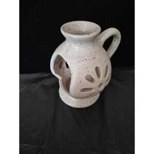 White and brown pottery open candle holder designed to hold sitting candles. 
